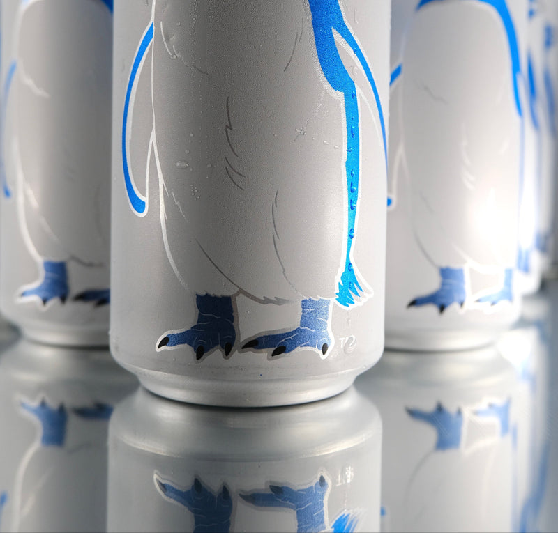 Cans with penguin design on a reflective surface